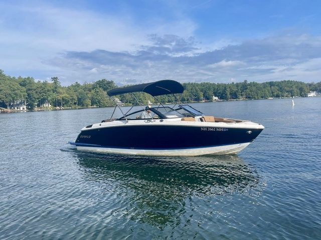 Cobalt R6 2025 Cobalt R6 boat on a serene lake with lush green shoreline.