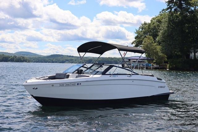 Cobalt R6 2025 Cobalt R6 boat on a scenic lake with trees and hills in the background.