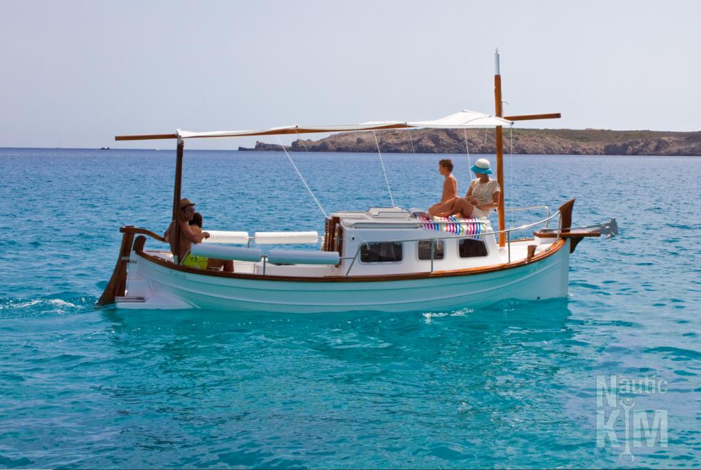 Llaüts Tiburón 37 CABINADO ELECTRICO 2023 Llaüts Tiburón 37 Cabinado Eléctrico boat on clear blue water, with passengers relaxing.