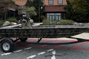 Tracker Grizzly 1860 CC 2026 Tracker Grizzly 1860 CC boat on trailer, parked outdoors near a building.