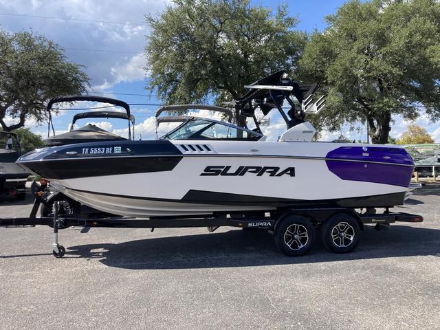 Supra SA 400 2016 Supra SA 400 boat on trailer, white and purple, parked outdoors.