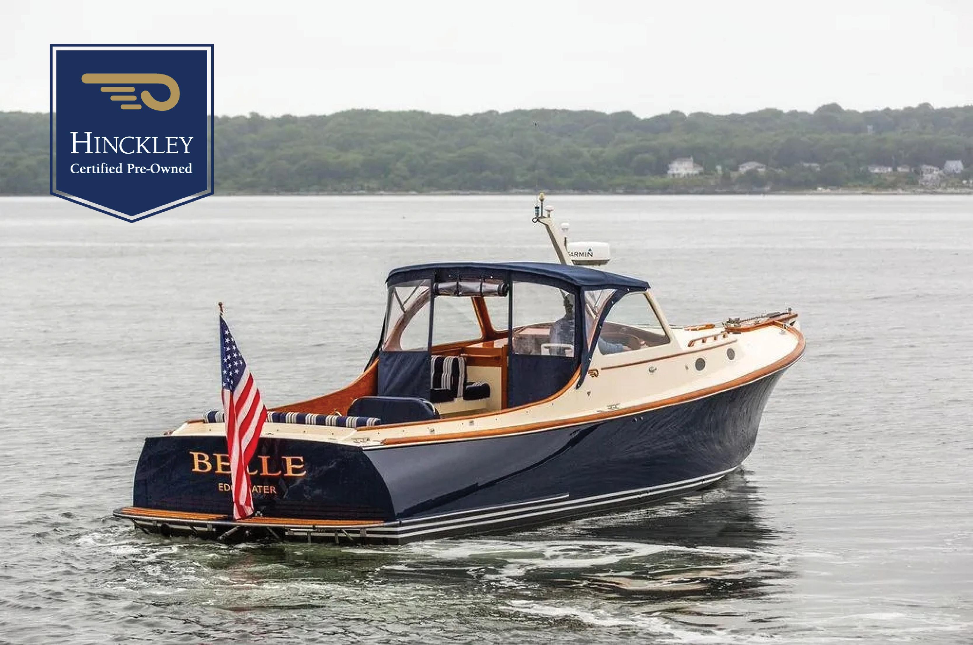 Hinckley Picnic Boat 1998 Hinckley Picnic Boat on water, certified pre-owned, with American flag, scenic background.