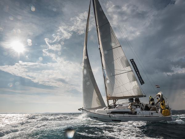 Dufour 382 Sailing yacht Dufour 382 (2016) navigating ocean waves under a cloudy sky.