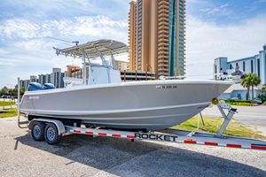 Contender 25 Tournament 2022 Contender 25T boat on trailer, urban background, clear sky.