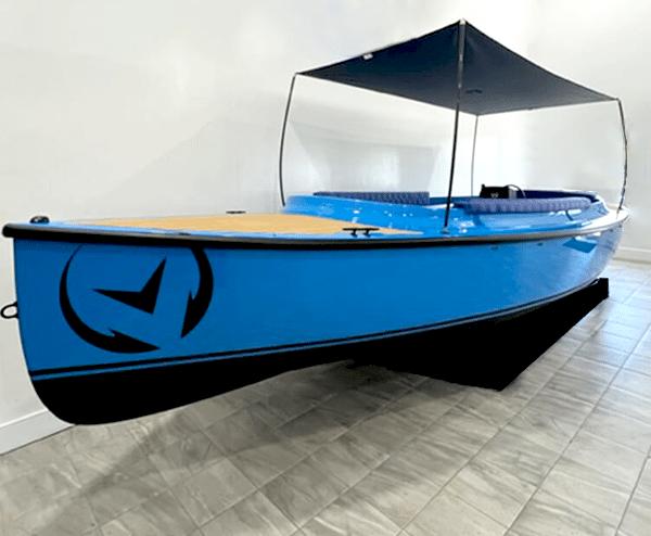 Vision Marine Technologies Fantail 217 2024 Vision Marine Technologies Fantail 217, blue electric boat with canopy, displayed indoors.
