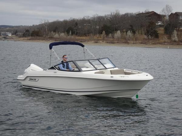 Boston Whaler 210 Vantage 2024 Boston Whaler 210 Vantage boat cruising on a lake with a person onboard.