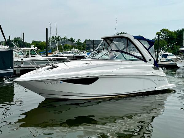 Regal 28 Express 2019 Regal 28 Express boat docked in marina, calm water, overcast sky.