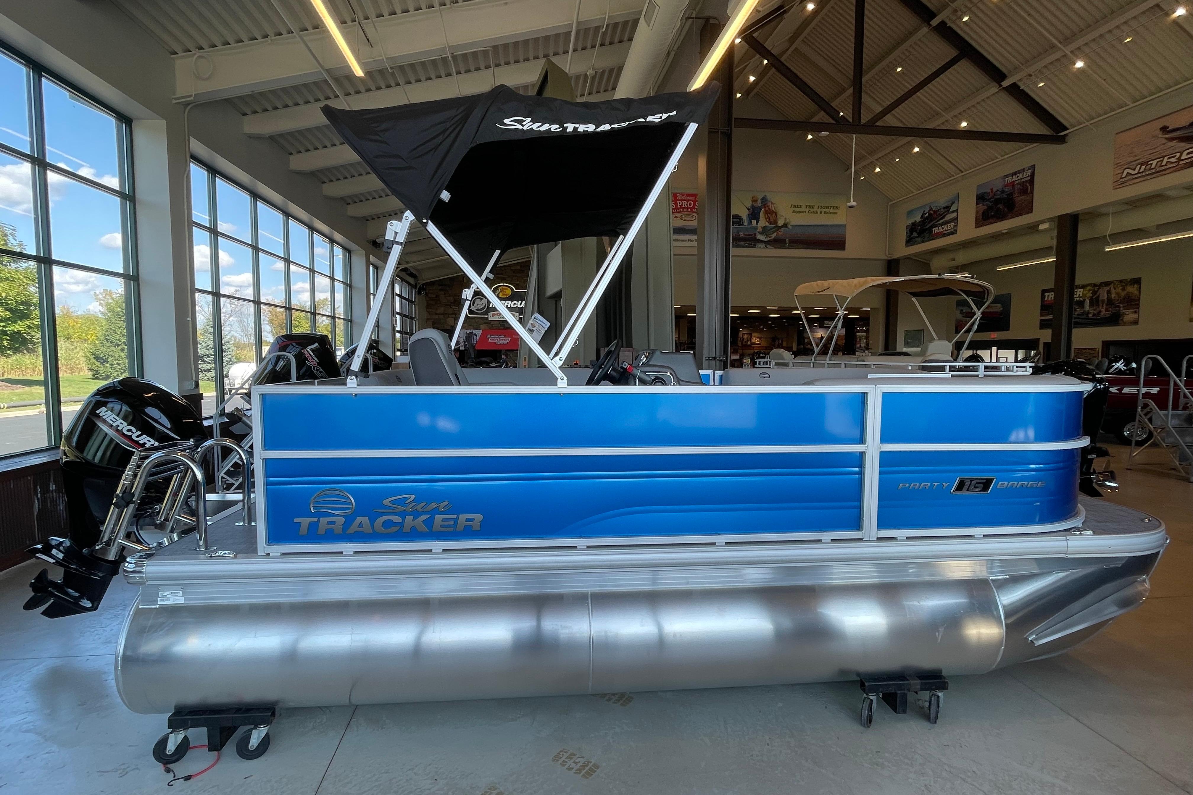 Sun Tracker Party Barge 16 DLX 2026 Sun Tracker Party Barge 16 DLX pontoon boat displayed indoors.