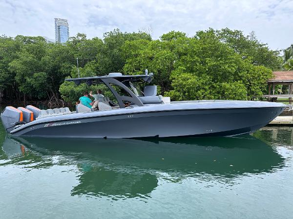 Midnight Express 37 Open 2025 Midnight Express 37 Open boat on calm water near lush greenery.