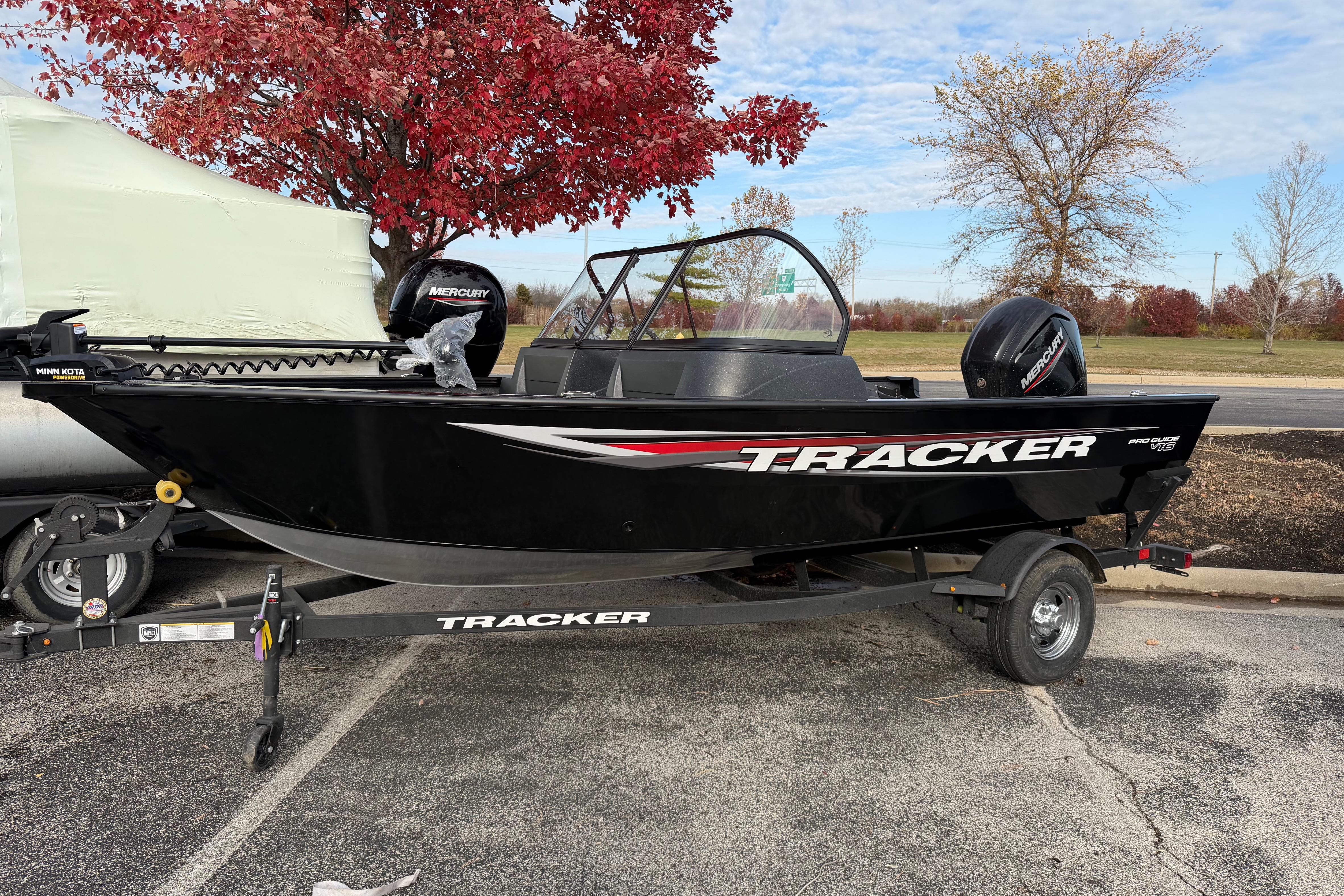 Tracker Pro Guide V-16 WT 2026 Tracker Pro Guide V-16 WT boat on trailer, parked near autumn trees.