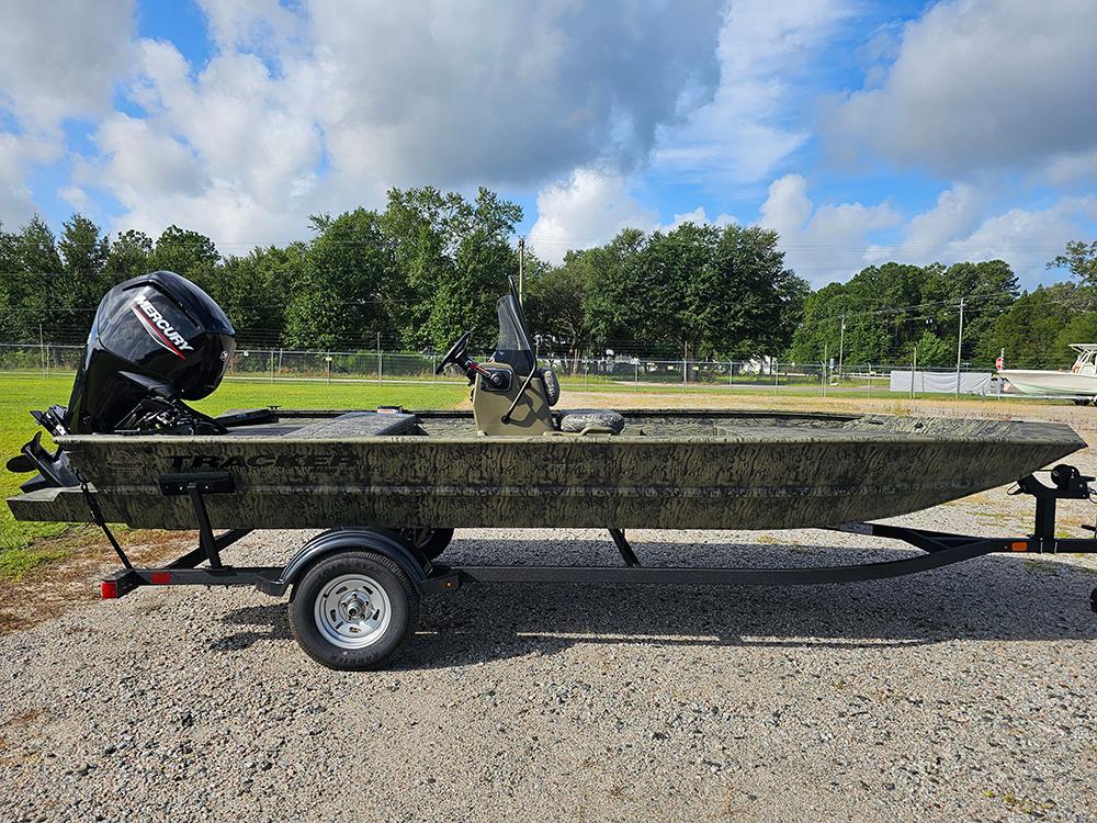 Tracker Grizzly 1860 CC 2026 Tracker Grizzly 1860 CC boat on trailer, outdoors, with Mercury outboard motor.