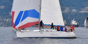 Beneteau First 40.7 Sailing yacht "Nirvana," Beneteau First 40.7, 2001, with colorful spinnaker on open water.