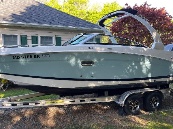 Four Winns HD5 OB 2022 Four Winns HD5 OB boat on trailer, parked beside a house.