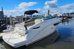 Sea Ray 260 Sundancer 2015 Sea Ray 260 Sundancer boat docked at marina under blue sky.