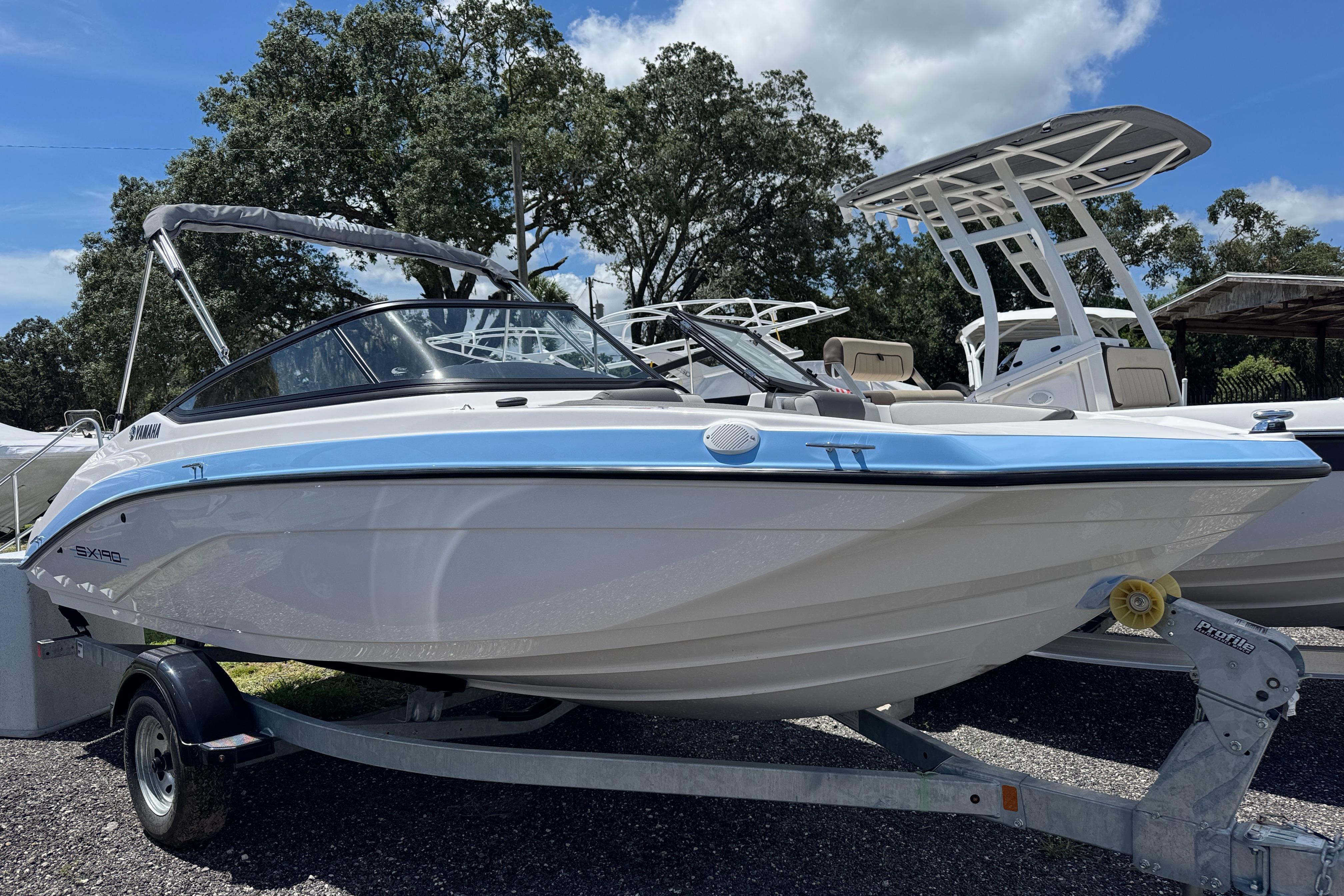 Yamaha Boats SX190 2025 Yamaha Boats SX190 on trailer, displayed outdoors under a clear sky.