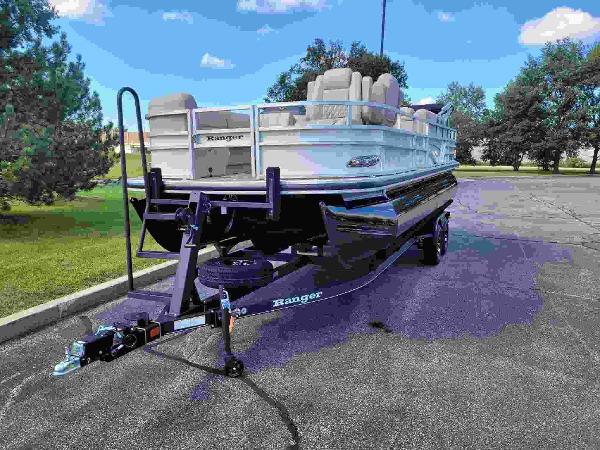 Ranger Reata 223FC 2024 Ranger Reata 223FC pontoon boat on a trailer in a parking lot.