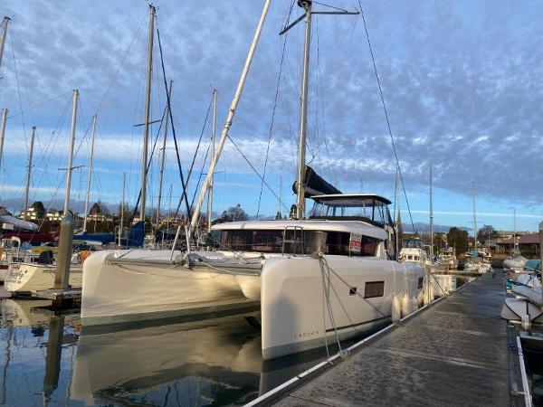 Lagoon 42 2024 Lagoon 42 catamaran docked at a marina under a cloudy sky.