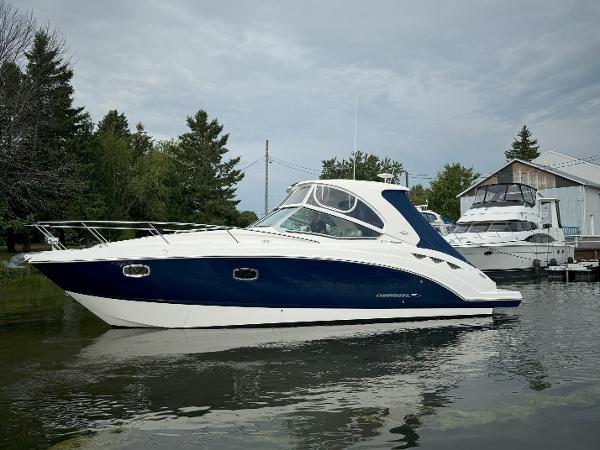 Chaparral 330 Signature 2013 Chaparral 330 Signature boat docked on calm water, surrounded by trees and buildings.