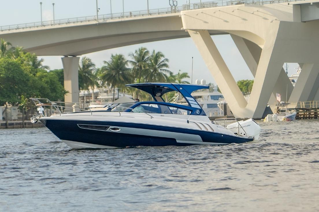 Hanover 305 White & Blue Edition 2024 Hanover 305 White & Blue Edition boat cruising under a bridge with palm trees.