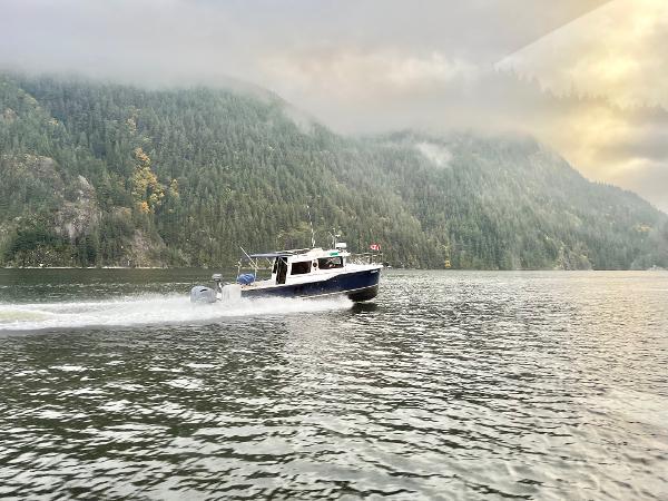 Ranger Tugs R-27 2018 Ranger Tugs R-27 cruising on a scenic lake with forested hills in the background.