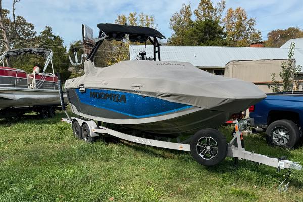 Moomba Mojo 2023 Moomba Mojo boat on trailer, covered, parked on grass.