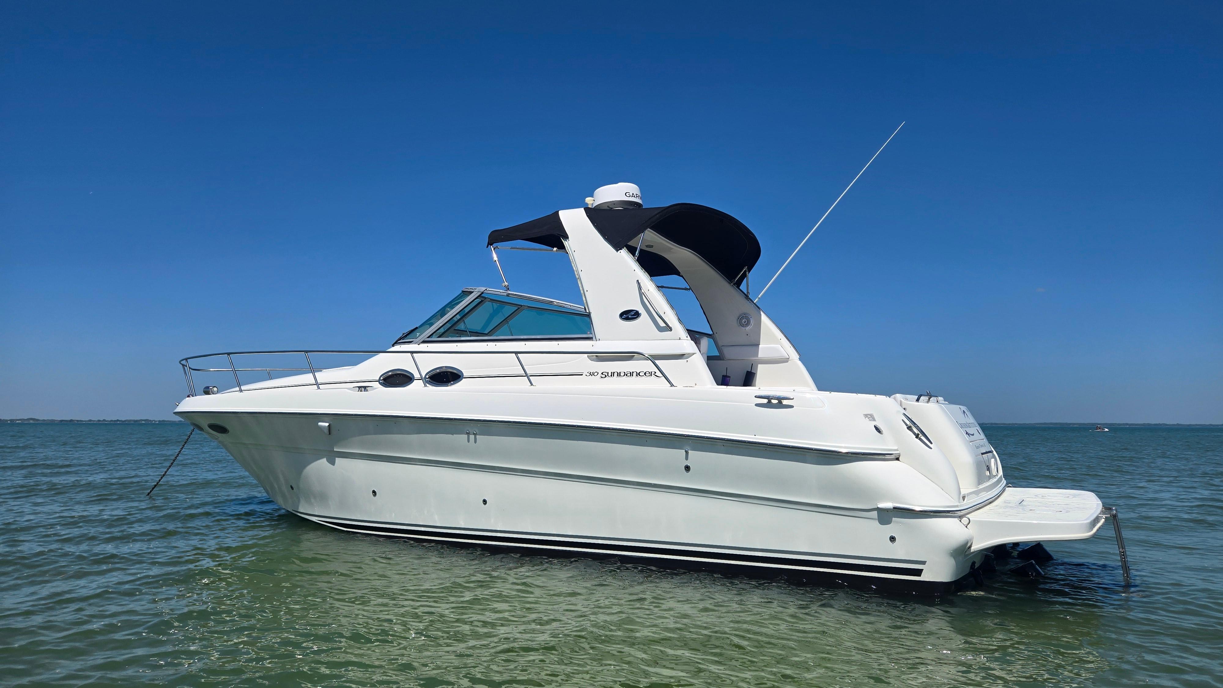 Sea Ray 310 Sundancer 2001 Sea Ray 310 Sundancer boat on calm water under clear blue sky.