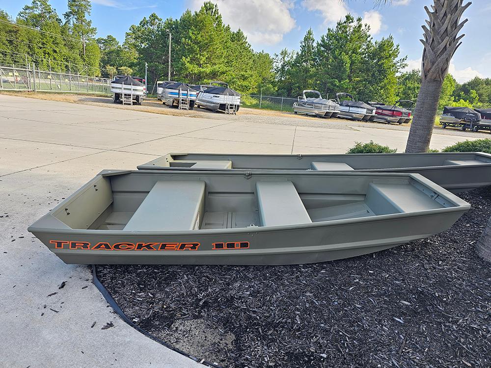 Tracker Grizzly 1036 Utility 2026 Tracker Grizzly 1036 Utility boat displayed outdoors, surrounded by trees and parked vehicles.
