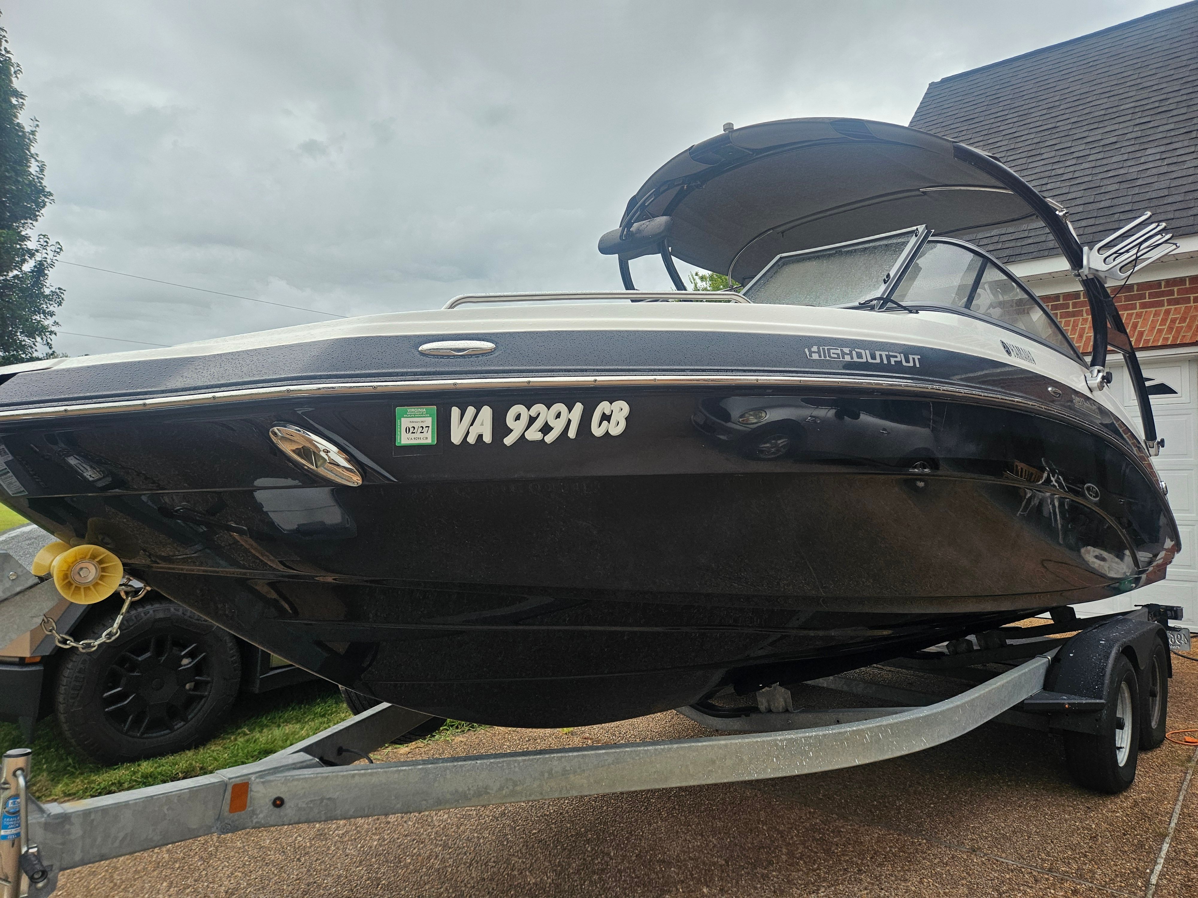 Yamaha Boats 242 Limited S 2012 Yamaha Boats 242 Limited S on trailer, black hull, parked in driveway.