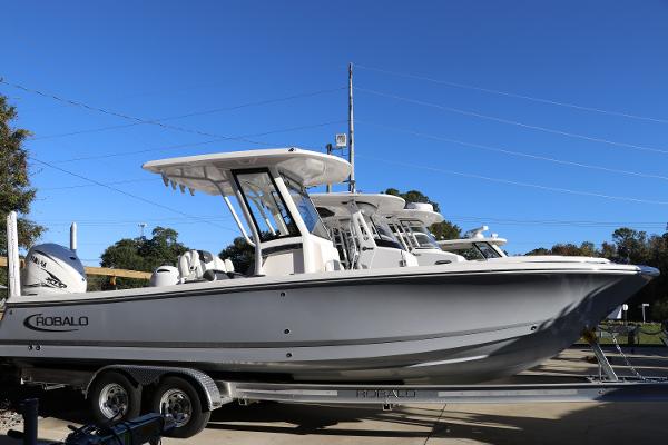 Robalo 266 Cayman 2024 Robalo 266 Cayman boat on trailer under clear blue sky.