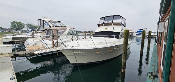 Viking 41 Convertible 1983 Viking 41 Convertible yacht docked at marina, calm water, overcast sky.
