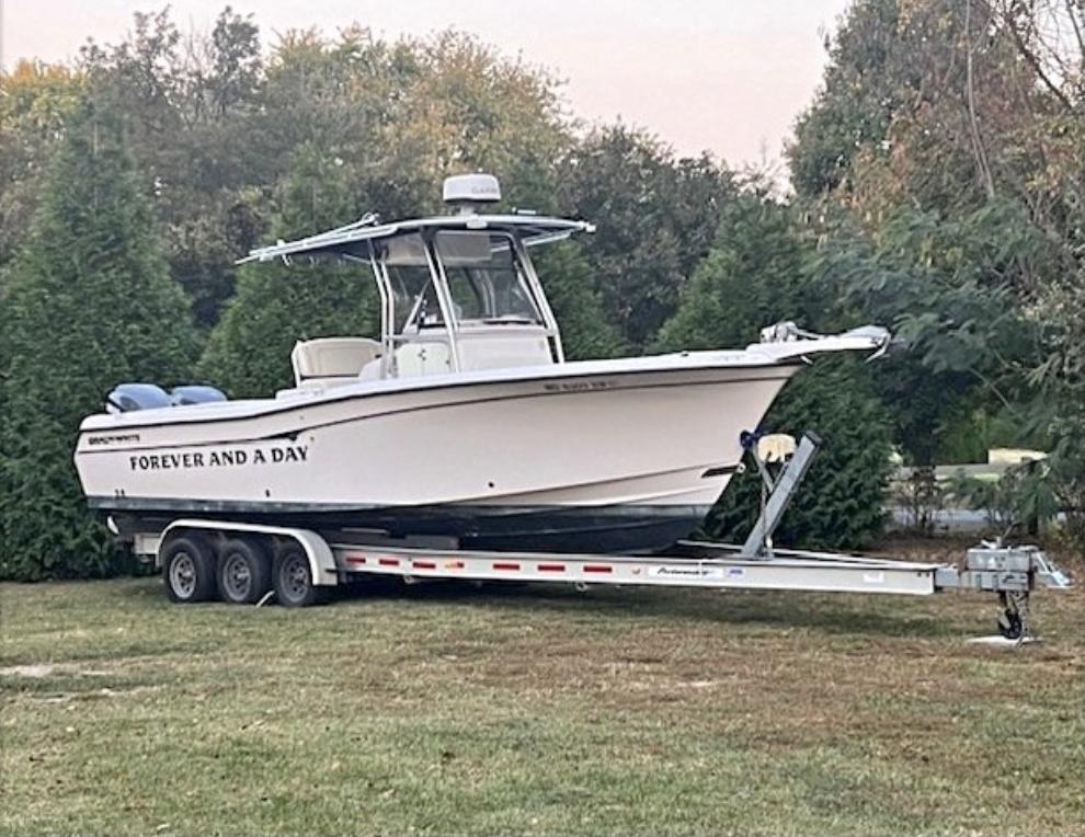 Grady-White 283 RELEASE 2003 Grady-White 283 RELEASE boat on trailer, parked on grass, surrounded by trees.