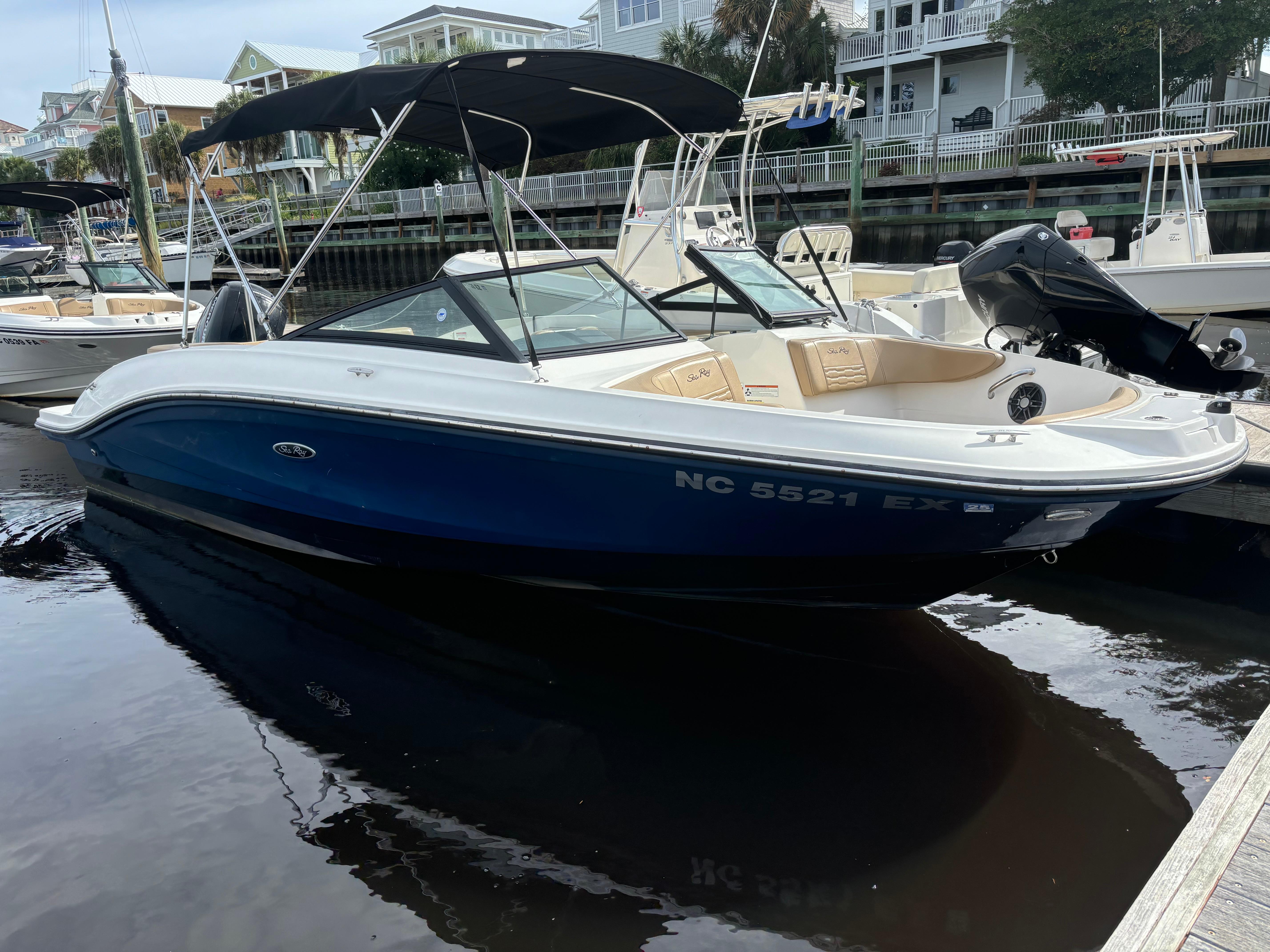 Sea Ray SPX 210 Outboard 2022 Sea Ray SPX 210 Outboard boat docked in marina, featuring sleek design and blue hull.