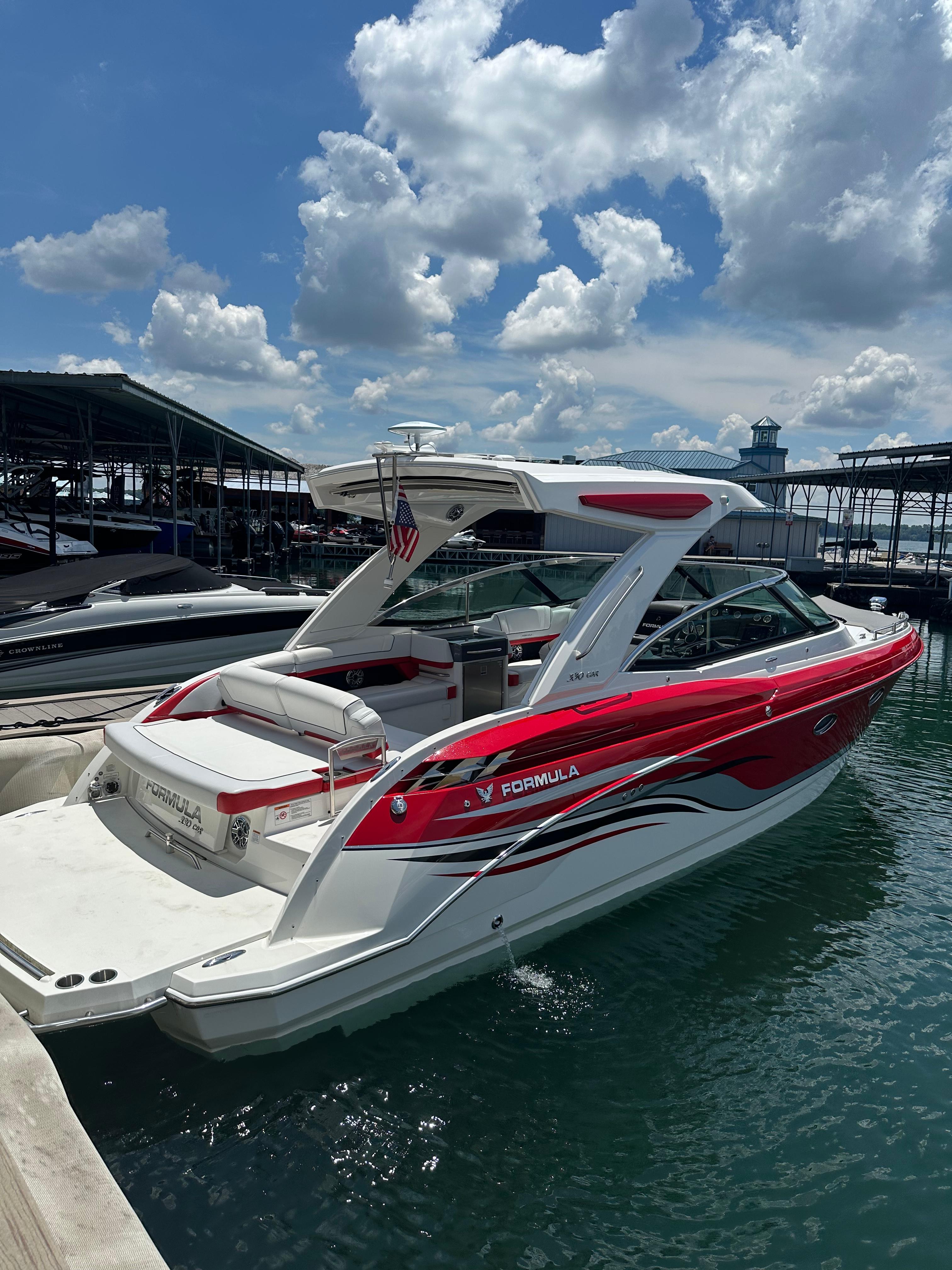 Formula 330 CBR 2024 Formula 330 Crossover Bowrider I/O in marina, vibrant red and white design.