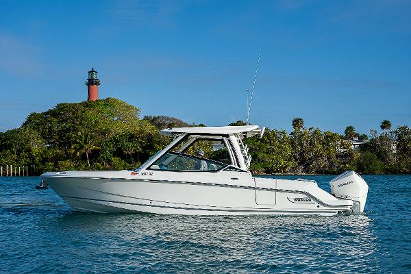 Boston Whaler 280 Vantage 2021 Boston Whaler 280 Vantage boat on water near lighthouse and trees.