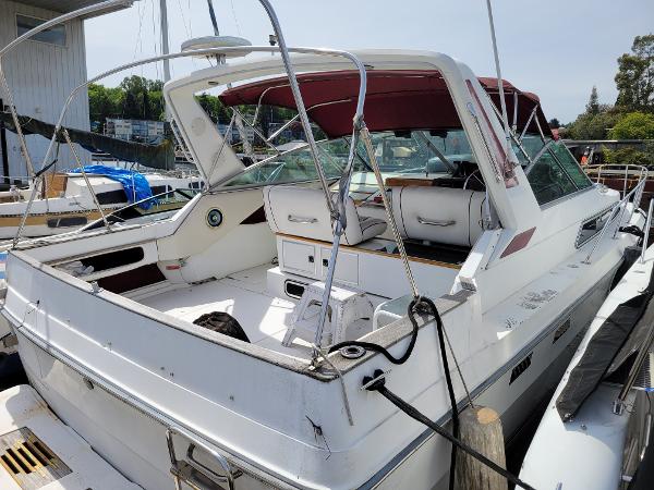 Sea Ray 340 Sundancer 1989 Sea Ray 340 Sundancer boat docked, featuring spacious deck and maroon canopy.