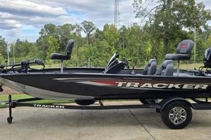 Tracker Pro Team 190 2026 Tracker Pro Team 190 boat on trailer, parked outdoors with trees in background.