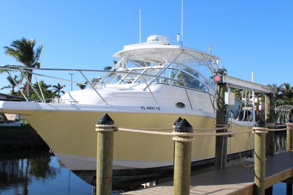 Pro-Line 32 Express 2006 Pro-Line 32 Express boat docked by palm trees under clear blue sky.