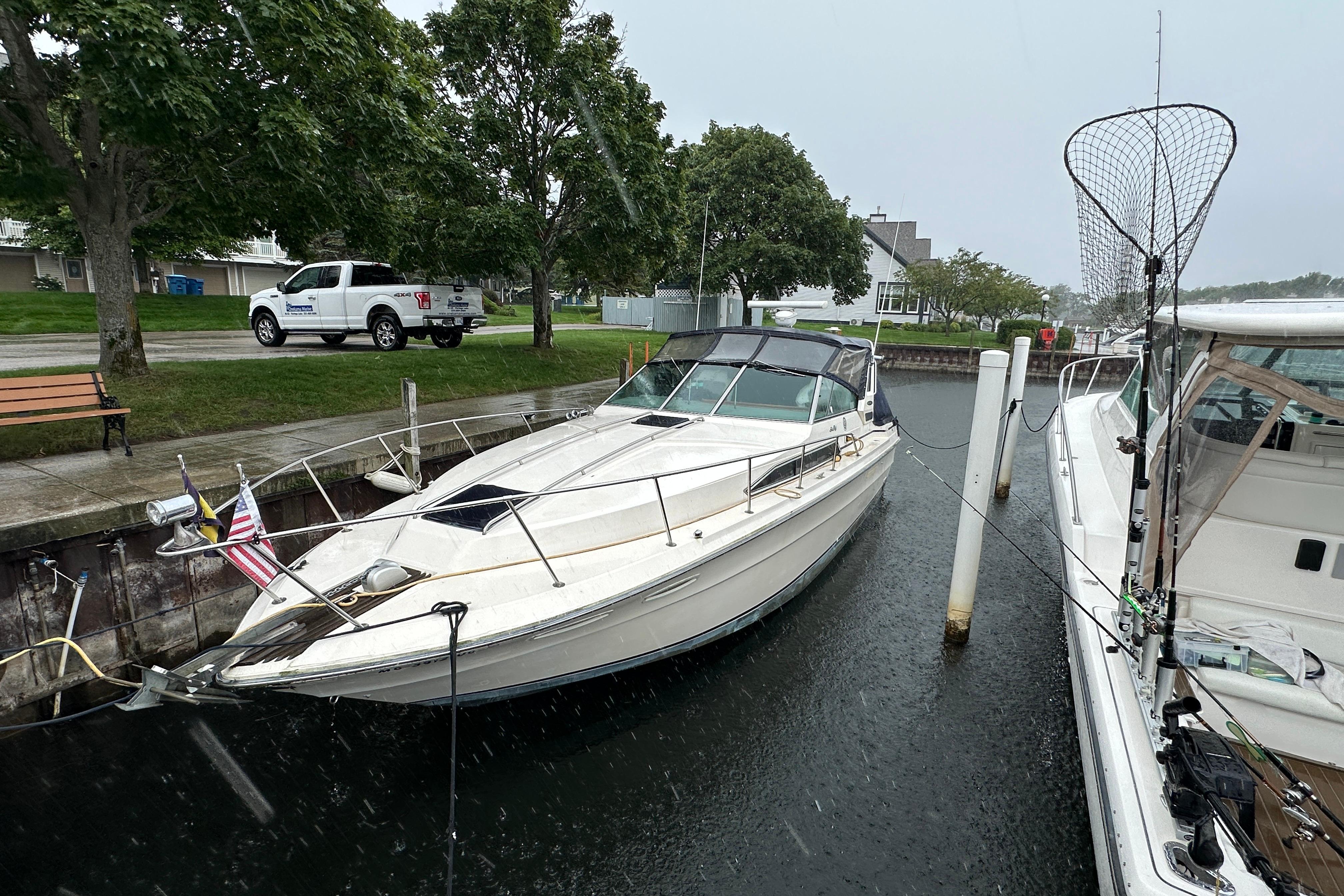 Sea Ray 340 Express Cruiser 1986 Sea Ray 340 Express Cruiser docked in a marina on a rainy day.