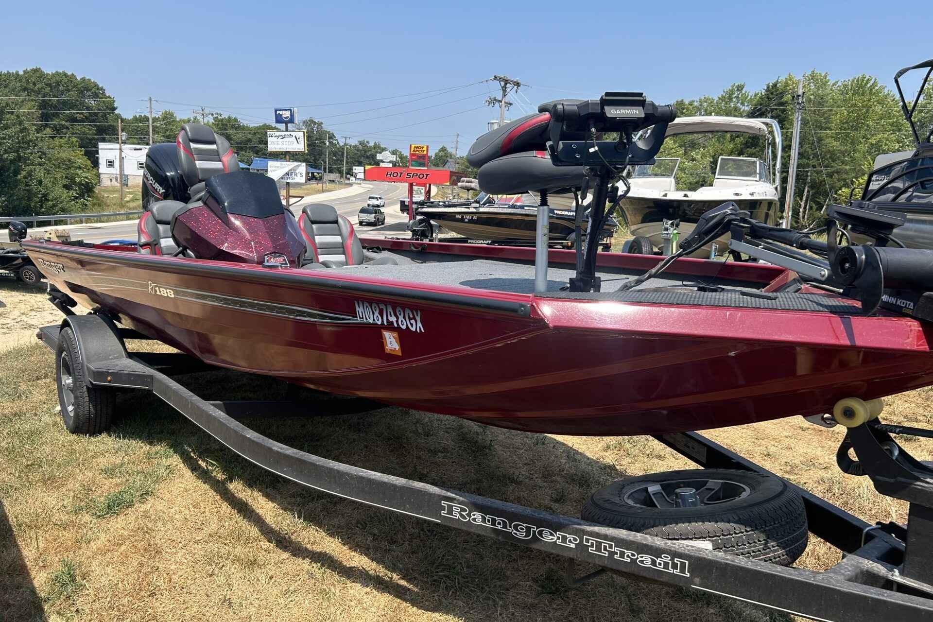 Tracker Pro Team 190 2019 Tracker Pro Team 190 boat on trailer, parked outdoors, with red exterior and fishing equipment.