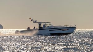 Nimbus T11 2024 Nimbus T11 boat cruising on sparkling water at sunset.