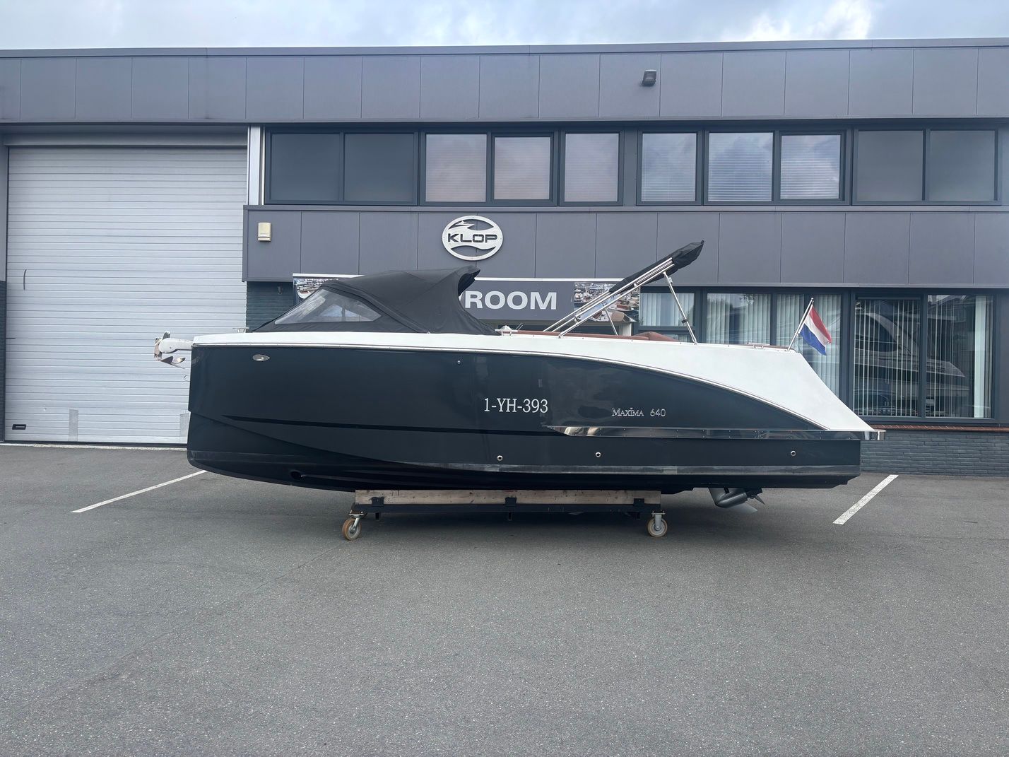 Maxima 640 met Honda 150 pk jong gebruikt! 2023 Maxima 640 boat with Honda 150 engine, parked outside showroom.