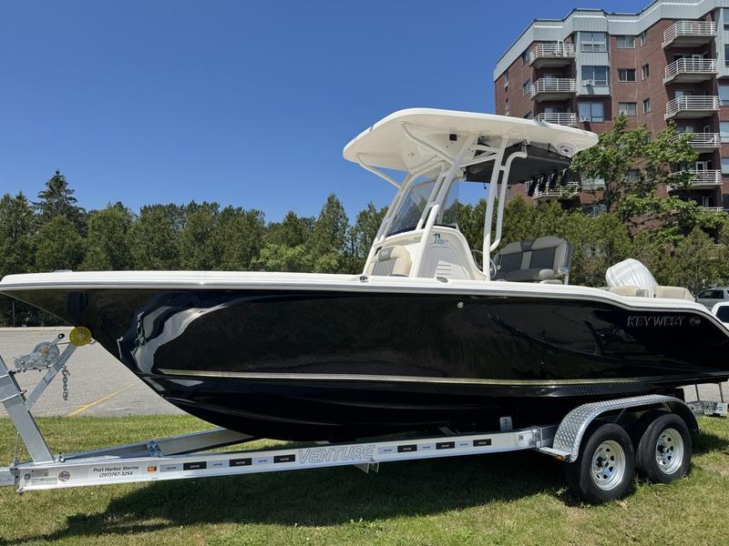 Key West 219 FS 2025 Key West 219 FS boat on trailer, parked outdoors near trees and buildings.