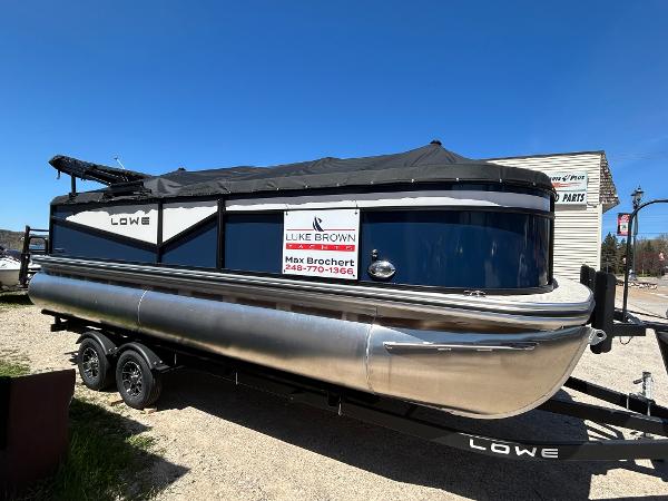 Lowe LS210WT 2025 Lowe LS210WT pontoon boat on trailer, covered and parked outdoors.