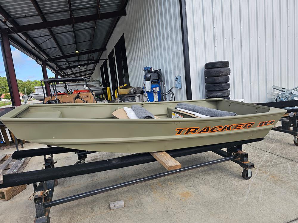 Tracker Grizzly 1036 Utility 2026 Tracker Grizzly 1036 Utility boat on display in a warehouse setting.