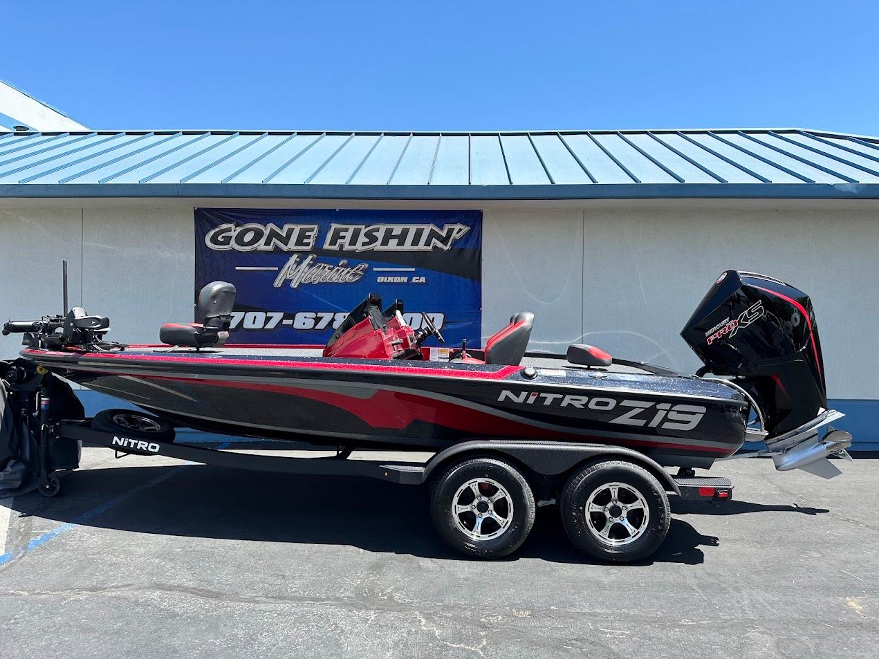 Nitro Z19 Pro 2025 Nitro Z19 Pro fishing boat with trailer, parked outside a marine shop.