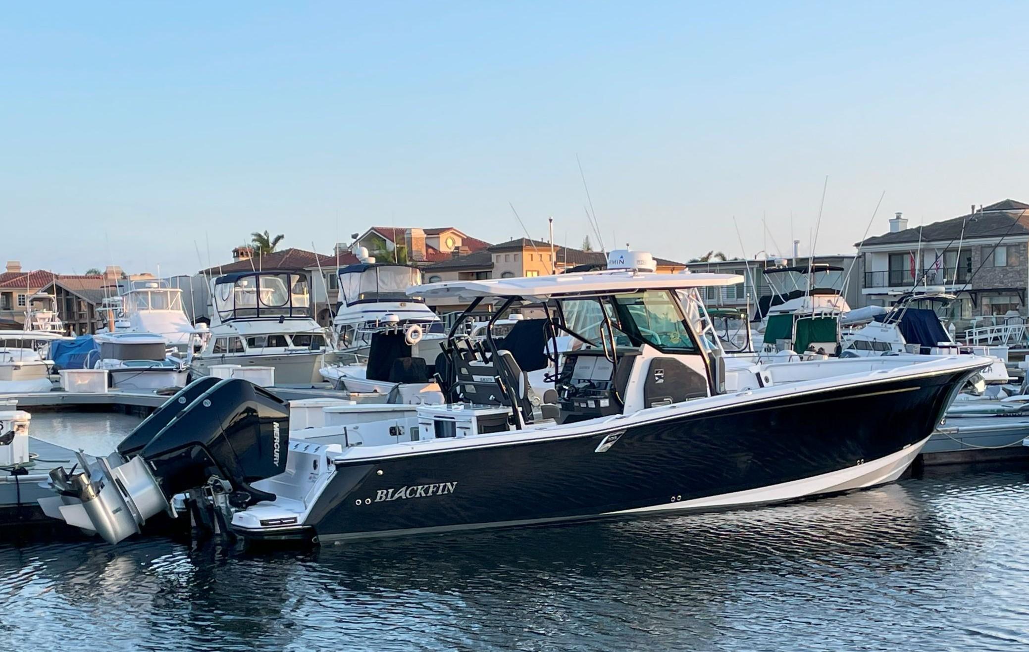Blackfin 332 CC 2024 Blackfin 332 CC boat docked in marina, surrounded by other vessels.