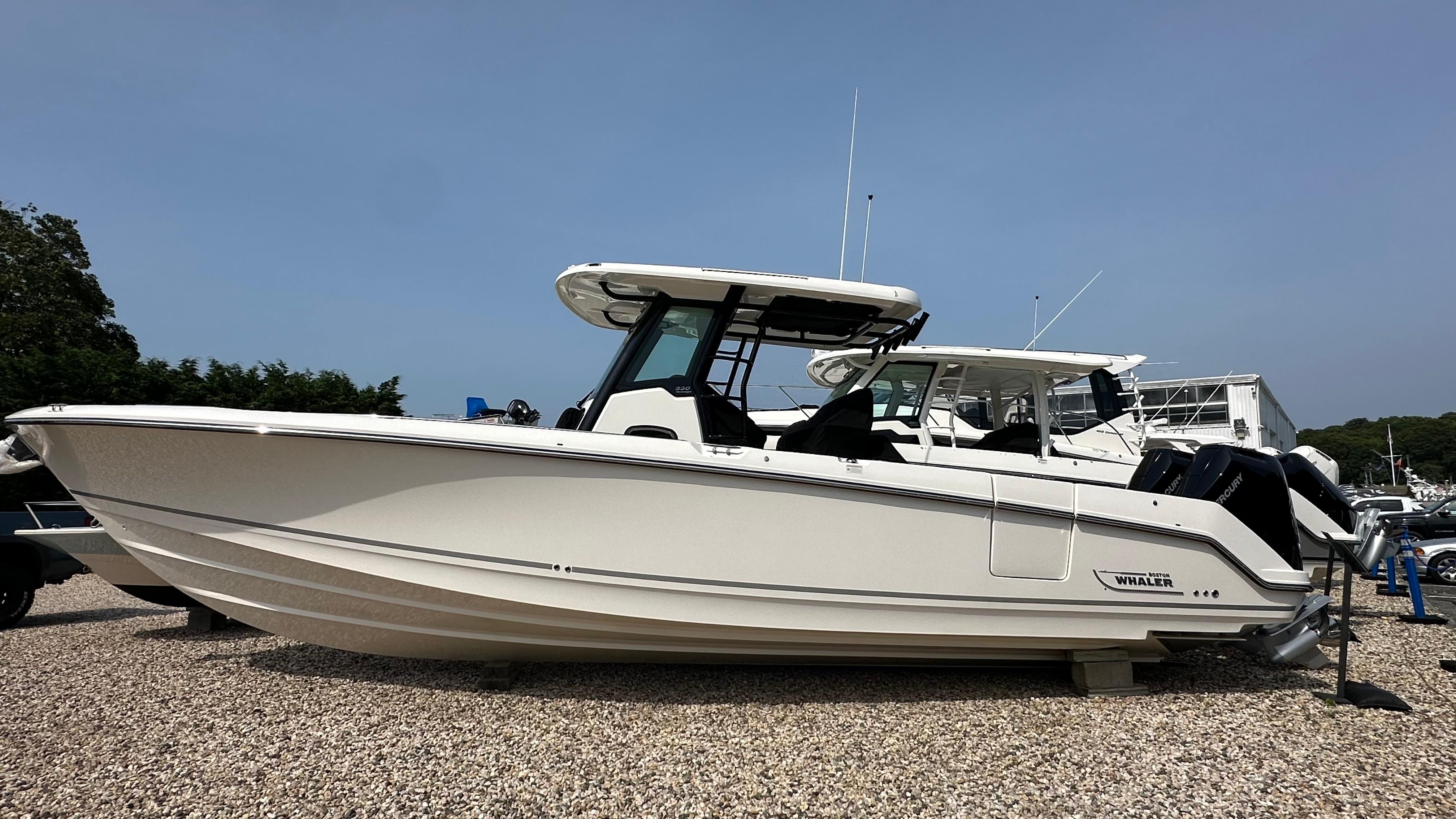 Boston Whaler 330 Outrage 2025 Boston Whaler 330 Outrage boat displayed on gravel lot.
