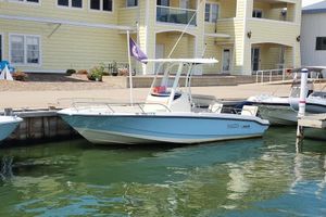 Boston Whaler 220 Dauntless 2022 Boston Whaler 220 Dauntless boat docked by a yellow building.
