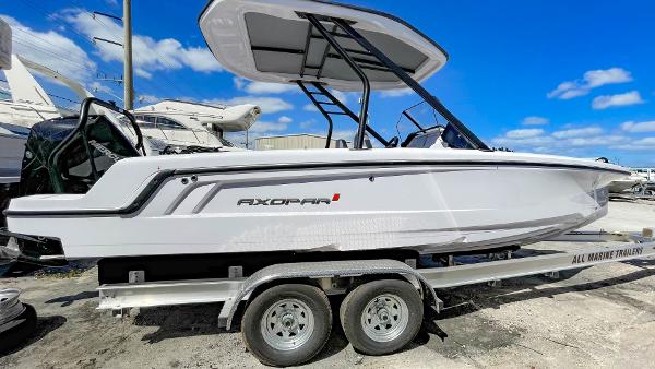 Axopar 22 T-Top 2023 Axopar 22 T-Top boat on a trailer under a clear blue sky.