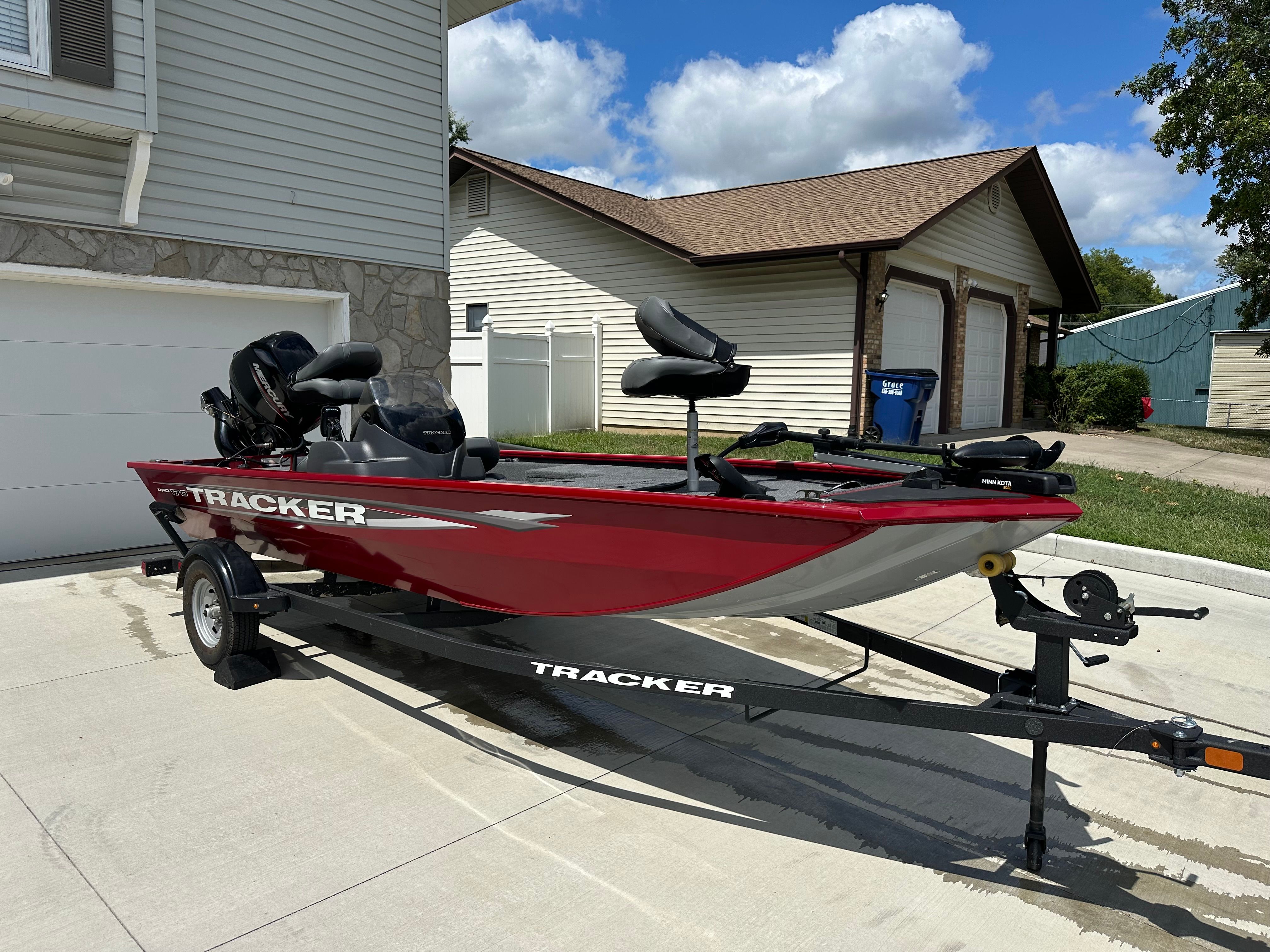 Tracker Pro 170 2025 Tracker Pro 170 boat on trailer, parked in a residential driveway under a clear sky.
